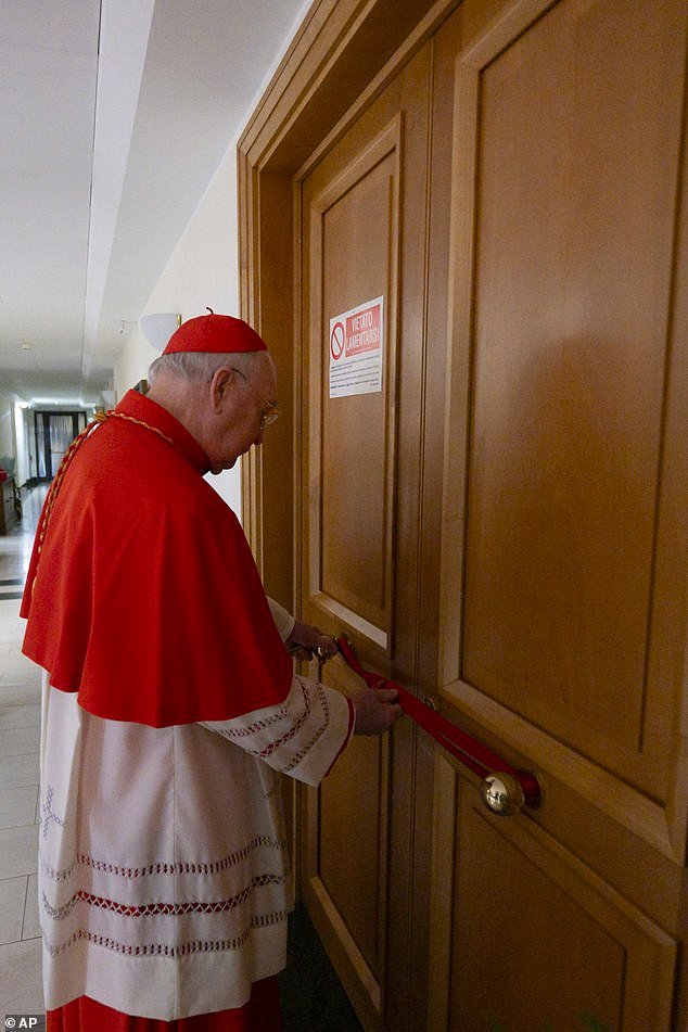 Cardinal Camerlengo Kevin Joseph Farrell, in a photograph released by the Vatican today, is seen sealing Pope Francis's private apartment inside the 'Domus Sanctae Marthae' hotel at the Vatican on Monday night