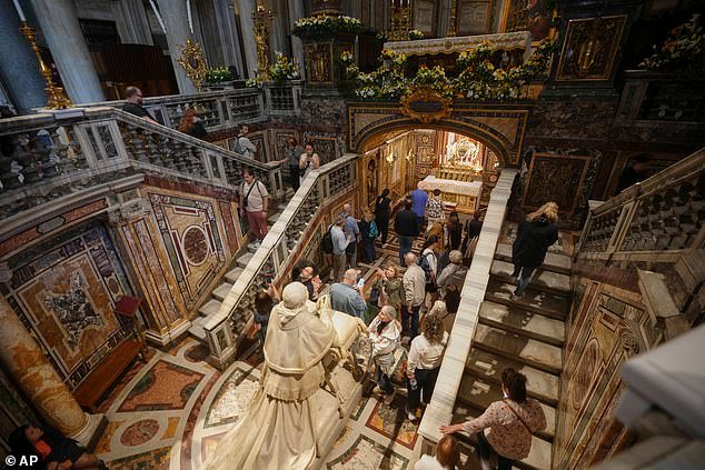 Nuns and the Catholic faithful gather by the statue of Pope Pius IX, inside in St. Mary Major basilica in Rome, where Pope Francis will be buried, today