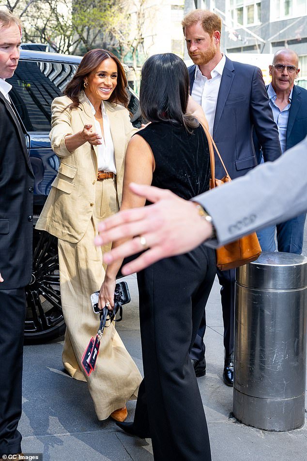 Prince Harry chaperoned his wife from their private car as she arrived at the venue in New York
