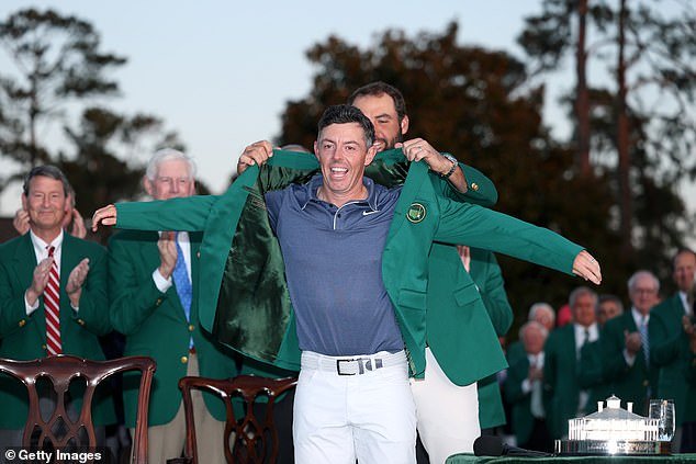 Scottie Scheffler of the United States puts the Green Jacket on Rory McIlroy of Northern Ireland during the Green Jacket Ceremony after the final round of the 2025 Masters Tournament