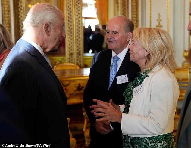 King Charles speaks with Alistair and Heather James, the parents of the late broadcaster Deborah James, during a reception in Buckingham Palace