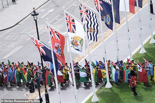 The flags of Commonwealth countries are brought into Parliament Square ahead of the military procession today