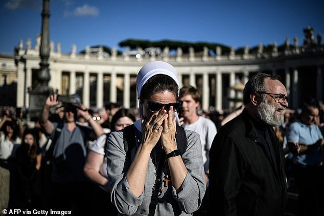 A nun reacts as white smoke (unseen) signals that cardinals elected a new pope during their conclave in the Vatican on May 8
