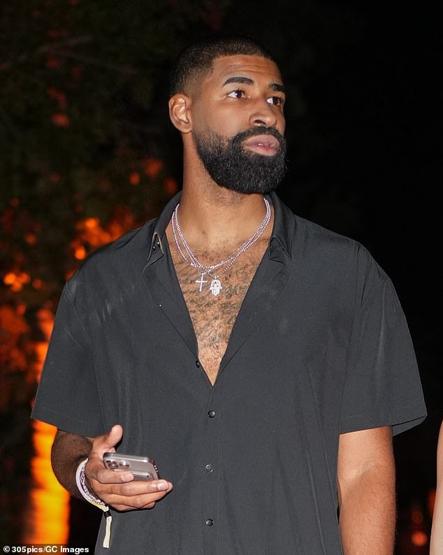 When the lensman asked if he was proposing now, the 6ft8in former pro basketball player smiled coyly: 'I can't tell you where I'm going to propose'