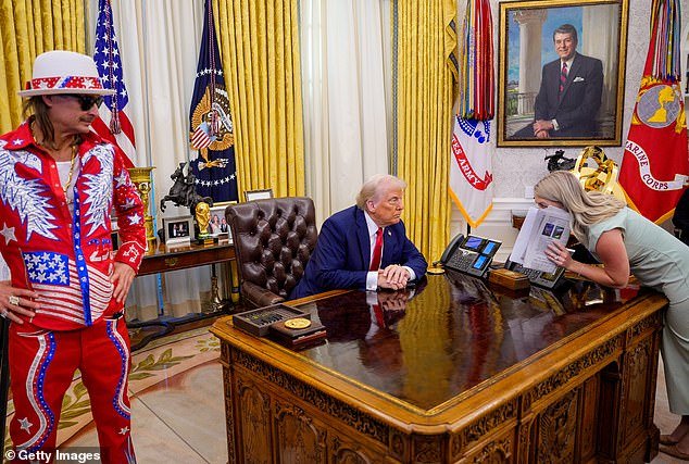 White House press secretary Karoline Leavitt speaks with President Donald Trump in the Oval Office as Kid Rock stands by