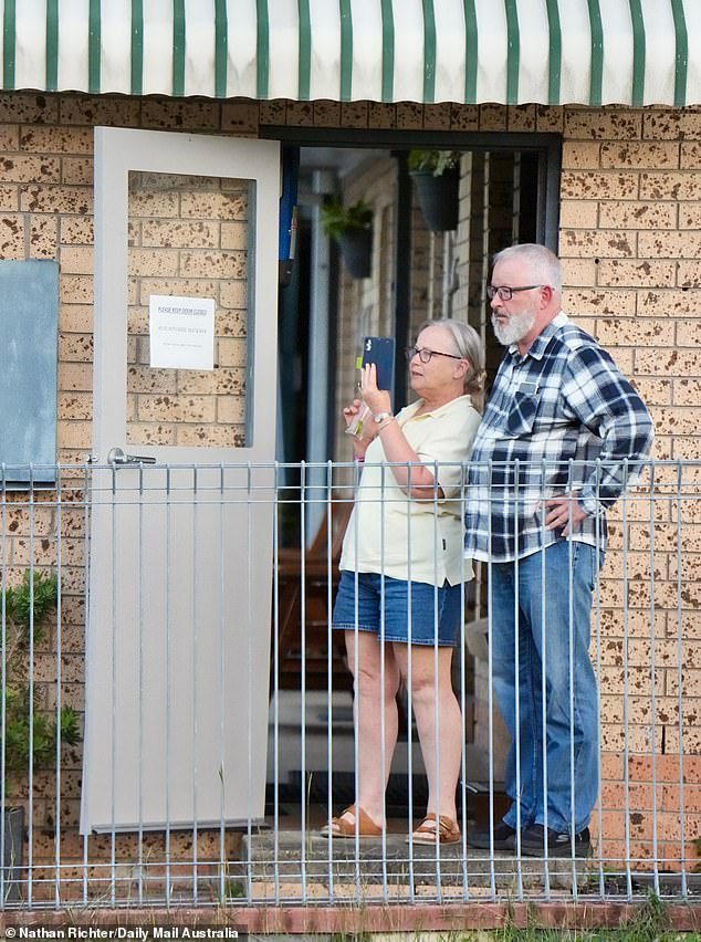Neighbours nearby were seen watching on as police searched the Gin Gin property