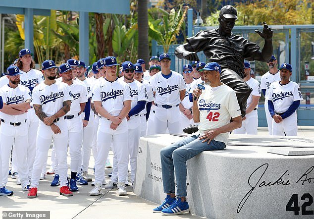 Kareem Abdul-Jabbar speaks during a ceremony honoring Jackie Robinson as members of the Los Angeles Dodgers look on at Chavez Ravine on Tuesday afternoon