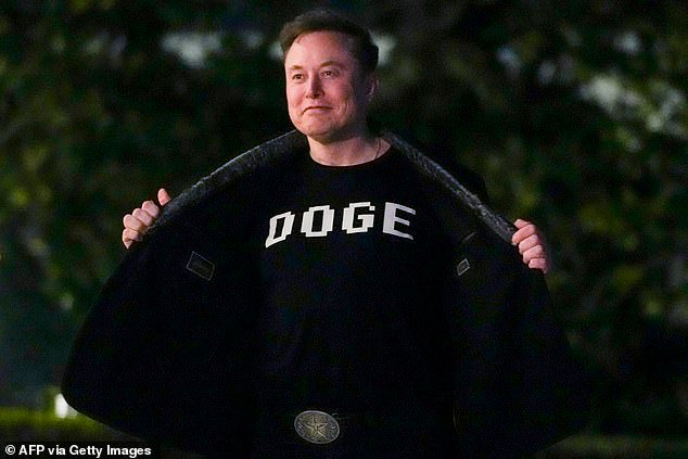 Elon Musk shows off a shirt that says "DOGE" as he walks on the South Lawn of the white House after stepping off Marine One