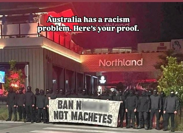 Pictured is a post to social media depicting the masked white supremacist group prominently displaying the offensive sign outside the popular shopping centre