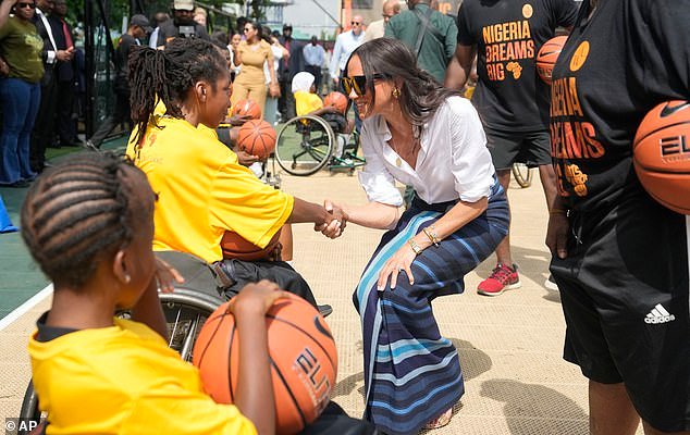 The Duchess of Sussex shake hands with a girl on a wheelchair during the Giant of Africa Foundation at the Dream Big Basketball clinic in Lagos Nigeria on Sunday, May 12, 2024