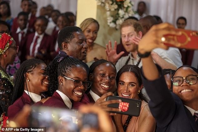 Meghan takes a selfie with students as she arrives with Harry during their visit at the Lightway Academy in Abuja, Nigeria on Friday, May 10, 2024