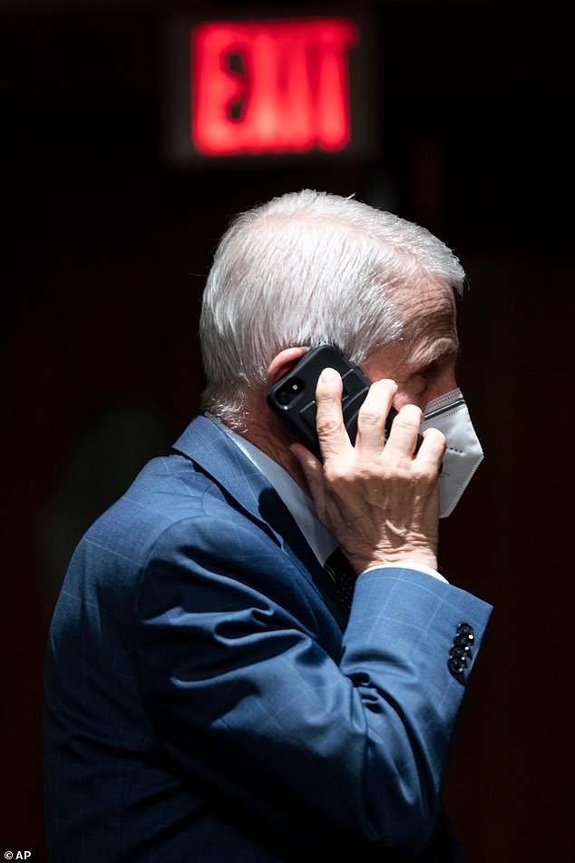 Fauci, pictured here making a phone call during a Senate hearing in 2022, has denied all allegations of covering up potential lab leak theories