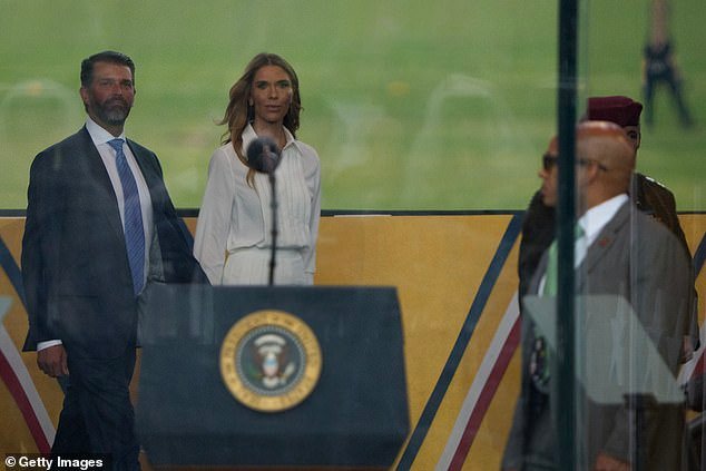 Donald Trump Jr. (left) walks into the viewing box with his girlfriend Bettina Anderson (right) ahead of Saturday's military parade