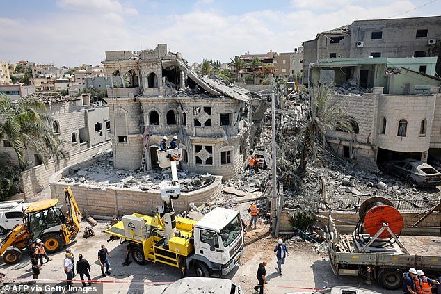 Rescue teams clear rubble in a neighbourhood in the northern Israeli village of Tamra, following an overnigh missile attack from Iran on June 15, 2025