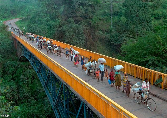 Rwandan refugees cross the bridge of Rumumo river which marks the border between Tanzania and Rwanda, Dec. 14, 1996. Hundreds of thousands of Rwandan refugees who fled their country after the 1994 civil war started their way towards Rwanda