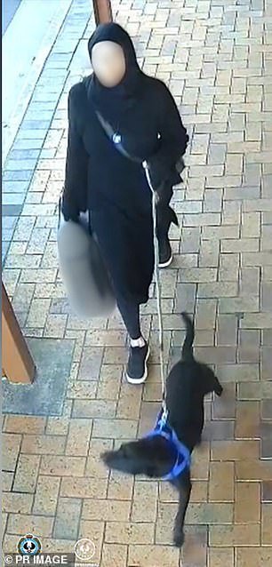 Tamika Chesser, dressed in black, is caught on CCTV walking her dog and carrying a bag