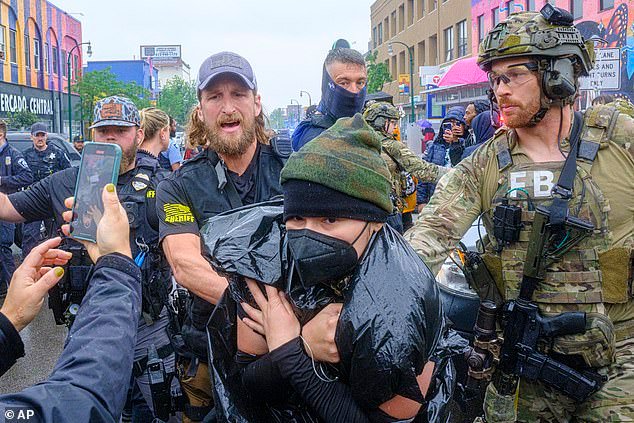 Community protesters confront law enforcement officers as federal agents conduct an operation in Minneapolis