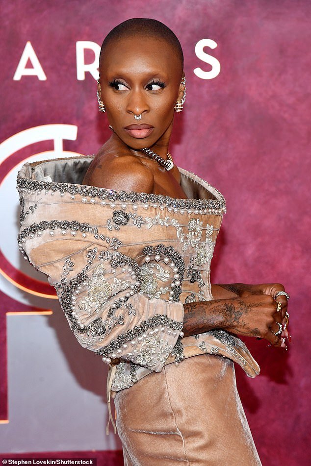 She paired the shirt - which was gigantic and fit awkwardly on her frame - with a floor-length silk skirt