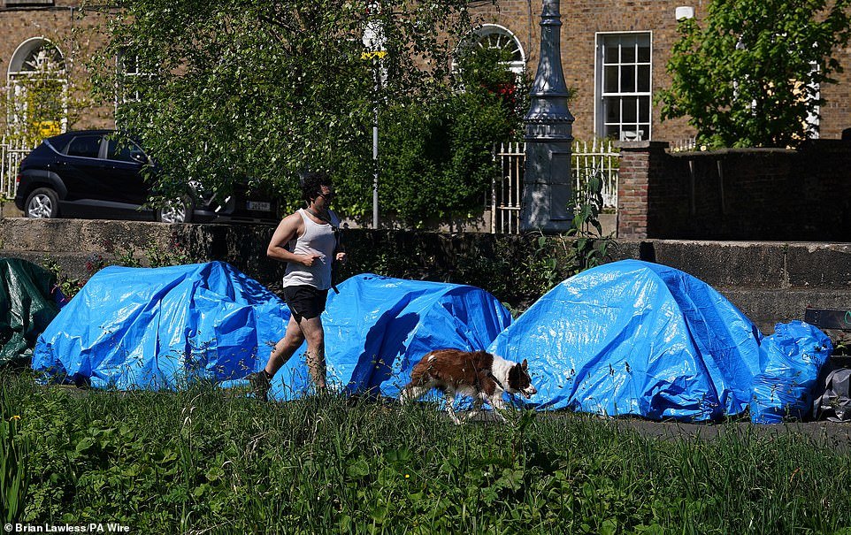 Migrants have pitched dozens of tents along the banks of Dublin's Grand Canal just days after hundreds were evicted from a 'shanty town' in the city. Photos show the blue tents lined up along a stretch of the canal near the International Protection Office (IPO) on Mount Street, where a makeshift migrant camp of more than 200 asylum seekers was dismantled on Wednesday by Irish authorities.