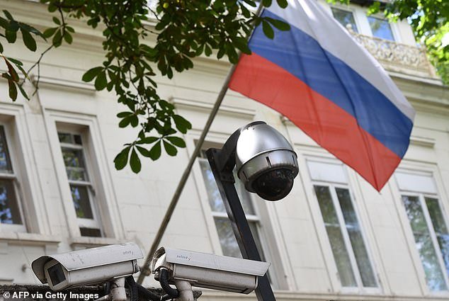 A Russian flag flies by surveillance cameras at the entrance to the Russian consulate in London