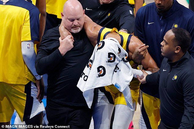 Haliburton had a towel over his head to try and hide his emotions after being led off the court
